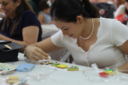 Niña decorando galletas como parte de los talleres navideños del Mercadito en el Centro Don Bosco.