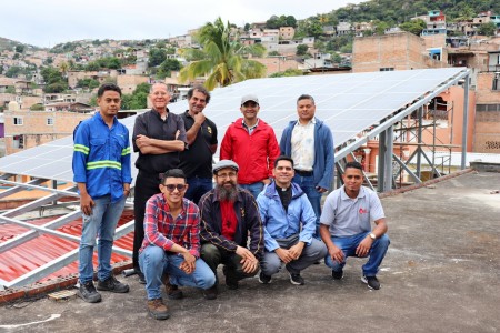 Representantes de la comunidad salesiana y de la compañía Tecknos Solar S.A. posan junto a la instalación de los paneles solares, símbolo del compromiso con la sostenibilidad en la Parroquia María Auxiliadora.