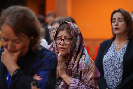 Feligres rezan con devoción el Santo Rosario ante la imagen de la Virgen del Rosario, durante la celebración de su solemnidad en la Parroquia El Espíritu Santo.