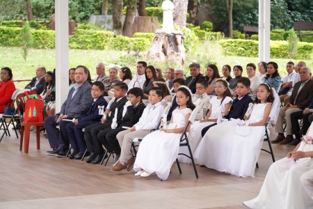 Un grupo de niños y jóvenes, junto a sus familias, durante la ceremonia de su Primera Comunión en la Parroquia El Espíritu Santo en Guatemala.