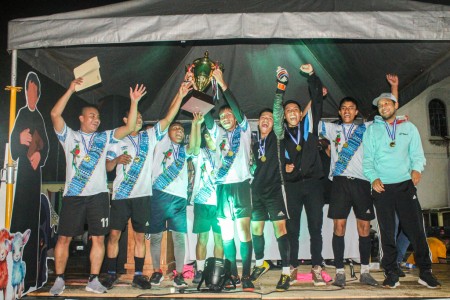 Uno de los equipos ganadores del Primer Torneo de Fútbol del Oratorio San José, celebran con entusiasmo tras recibir su trofeo en la gran final.