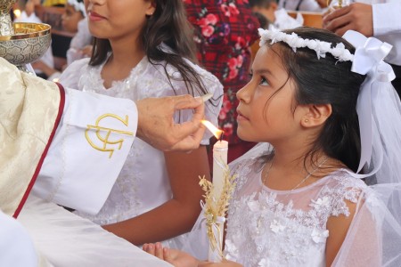  Con devoción y alegría, una niña recibe el Cuerpo de Cristo por primera vez durante la celebración de la Primera Comunión en la Parroquia María Auxiliadora de Comayagüela.