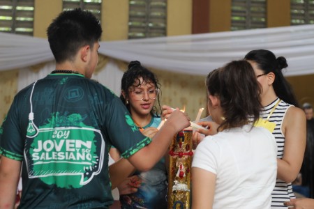Jóvenes participan en un momento de reflexión y oración, encendiendo sus velas con la luz del Cirio Pascual, símbolo de Cristo, durante el primer seguimiento del año en el Centro Don Bosco, Pérez Zeledón.