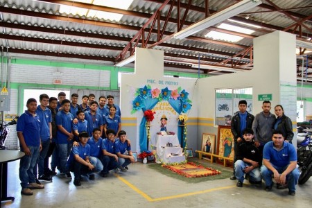 Estudiantes del Centro de Formación Profesional San Juan Bosco posan junto al altar elaborado con dedicación en honor a María Auxiliadora, reflejo de su fe y creatividad.