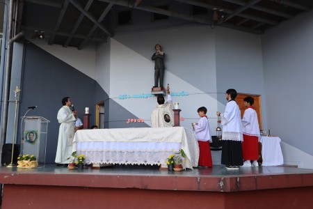 El padre Ramiro Aguirre bendice la imagen de Santo Domingo Savio en el marco de su festividad y del 25.º aniversario de la Escuela San Juan Bosco, uniendo la fe y la historia de esta comunidad educativa salesiana.