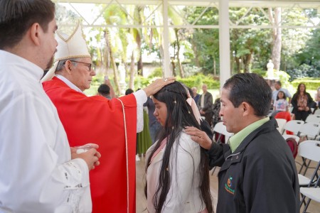 Monseñor Carlos Enrique Herrera, obispo auxiliar, impone las manos sobre los confirmandos durante la celebración del Sacramento de la Confirmación en la Parroquia El Espíritu Santo.
