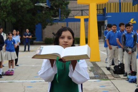Una estudiante del Instituto Salesiano San Miguel lleva solemnemente la Biblia durante la entronización, signo de fe y compromiso con la Palabra de Dios.