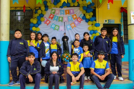 Estudiantes del Colegio Salesiano Don Bosco posan junto a la imagen de San Juan Bosco, expresando con alegr&iacute;a su amor y devoci&oacute;n al Padre y Maestro de la Juventud.