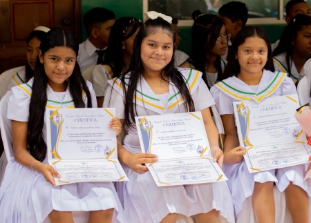 Estudiantes muestran con alegría sus diplomas de promoción.