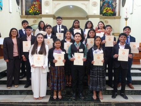 Un grupo de jóvenes, parte de los 130 confirmados, posa en el altar de la parroquia salesiana de San Pedro Carchá tras recibir el sacramento de la Confirmación, acompañados por la alegría y el respaldo de su comunidad.