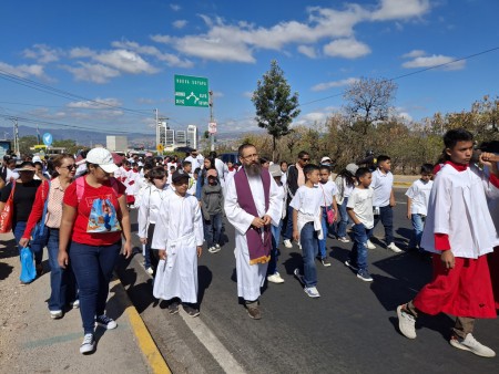 El Padre René Guzmán, SDB, acompaña a los monaguillos de la Parroquia María Auxiliadora en la procesión hacia la Basílica de Suyapa, un recorrido de fe y devoción en el marco del Jubileo Arquidiocesano.