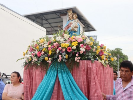 Feligreses acompañan con devoción la imagen de María Auxiliadora durante la procesión, expresando su fe y amor a la Virgen que camina junto a su pueblo como Madre y Protectora.