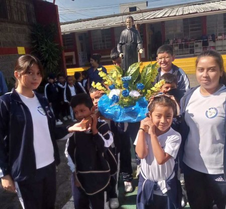Estudiantes del Centro Escolar Miguel Magone llevan en procesión la imagen de Don Bosco, expresando su cariño y gratitud al Padre y Maestro de la juventud.