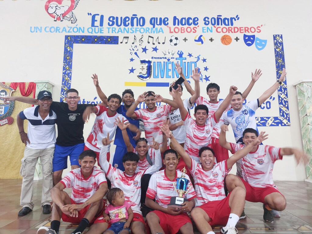  Un grupo de jóvenes celebra su victoria en el campeonato del Oratorio San Juan Bosco, mostrando con orgullo el trofeo que simboliza su esfuerzo y dedicación. 