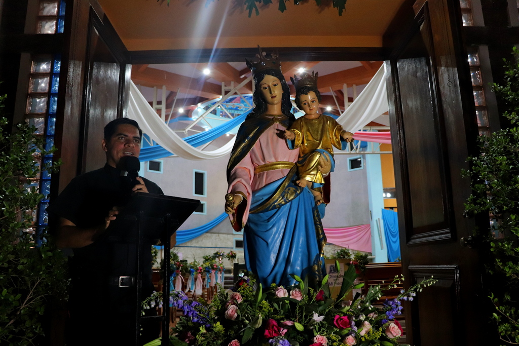 El padre Efrén Artiga, SDB, imparte la bendición con la imagen de María Auxiliadora, llenando de gracia y esperanza a los fieles al cierre de una noche colmada de fe y alegría en la sede parroquial de Comayagüela.