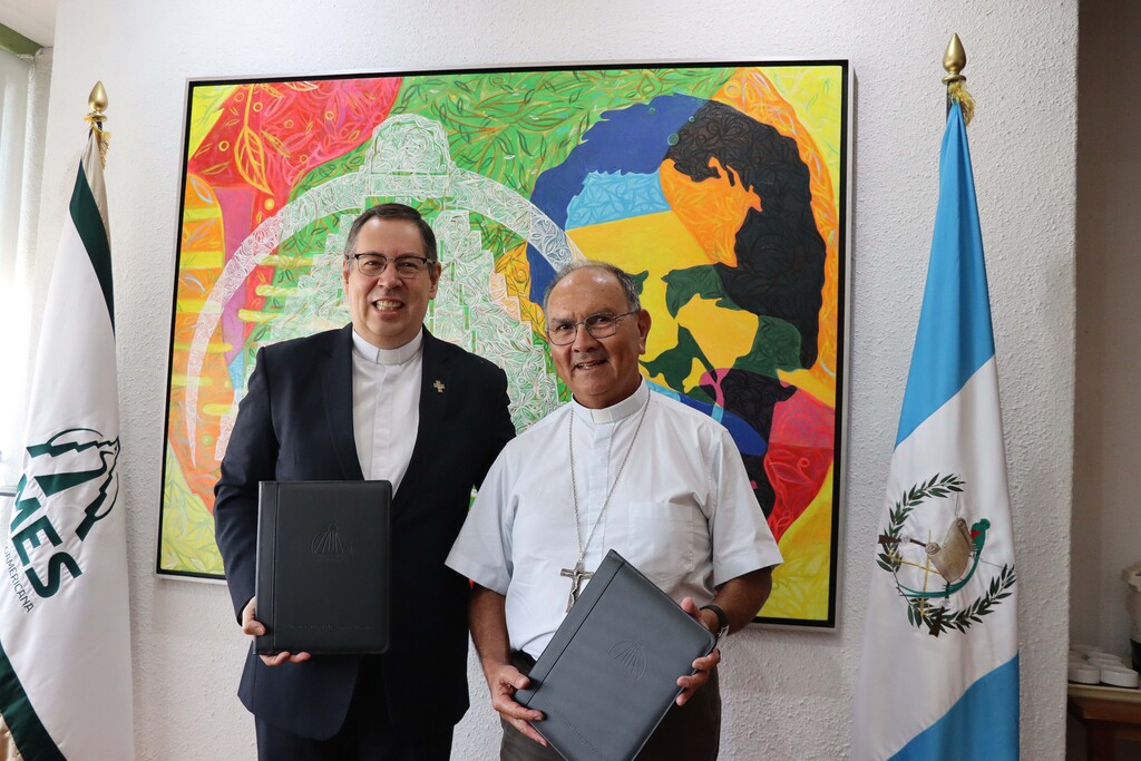 El pbro. Rómulo Gallegos Alvarado, SDB, Rector de la Universidad Mesoamericana, y Monseñor Rodolfo Valenzuela Núñez, representante de la Conferencia Episcopal de Guatemala, durante la firma del convenio de cooperación académica entre la Universidad Mesoamericana y el Seminario Mayor Nacional de la Asunción. El acuerdo fortalece la formación teológica y pastoral al servicio de la Iglesia y la sociedad guatemalteca.